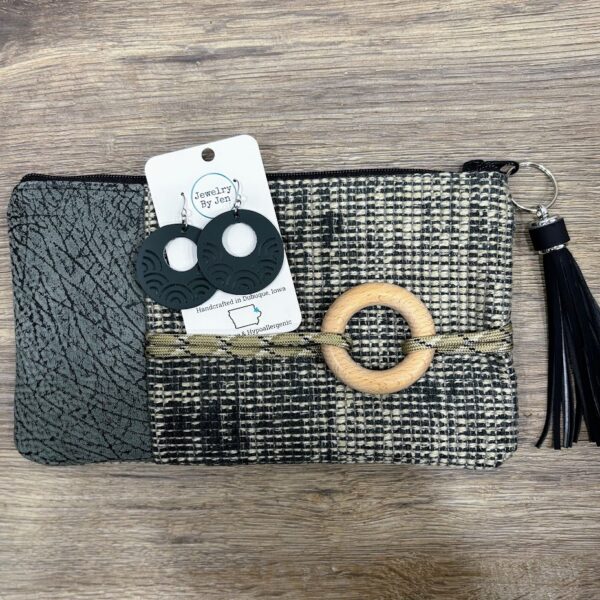 Custom bag-teal and cream fabric-teal leather-tan rope with wooden circle across front-black tassel-wood grain backdrop. Teal hoop earrings on white card.