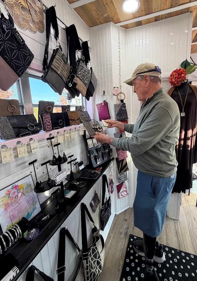 Man shopping in store with custom made bags and jewelry.